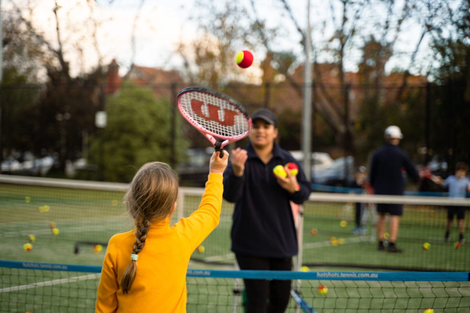 kid practice tennis serve