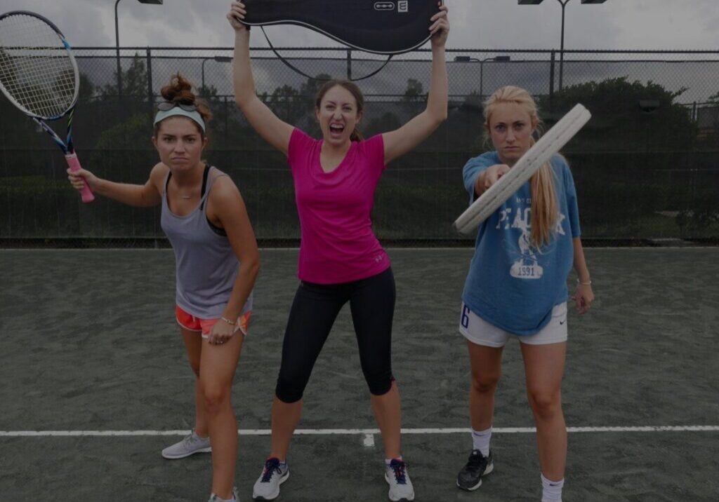 adults holding tennis racket having fun